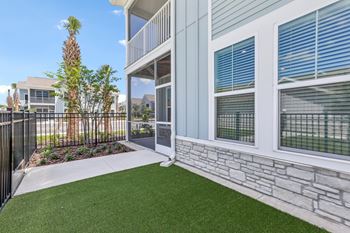 A balcony with a metal railing and a stone wall at The Junction at Rockledge Apartments, Rockledge, FL, 32955